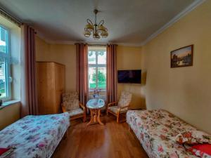 een slaapkamer met 2 bedden, een tafel en een raam bij Apartament Pułaskiego in Krynica Zdrój