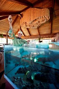 a man standing in front of a fish aquarium at Bluewater Maribago Beach Resort in Mactan