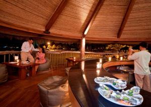 a group of people sitting at tables in a restaurant at Bluewater Maribago Beach Resort in Mactan