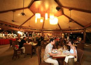 a group of people sitting at tables in a restaurant at Bluewater Maribago Beach Resort in Mactan