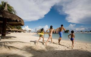 a group of people walking on the beach at Bluewater Maribago Beach Resort in Mactan