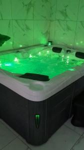 uma banheira com água verde na casa de banho em Spa NESSA em Saint-Andiol