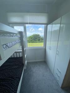 a bedroom with a bunk bed and a window at Bay view chalet, 28 Sea Valley in Bucks Mills