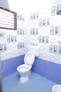 baño con aseo y azulejos azules y blancos en The Peaceful place, en Kāraikkudi