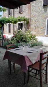 uma mesa com copos de vinho em cima em Agriturismo Casa Garello em Salice Terme