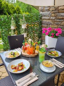 a table with plates of food on it at Aparthotel Góralski Spa in Białka Tatrzańska