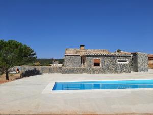 una casa de piedra con piscina frente a ella en EL ARA DE LOS ORISHAS, en Siete Aguas