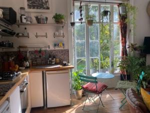 a kitchen with a table and a window with plants at Artistic spacious flat in central Brixton in London