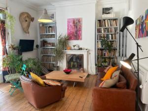 a living room with two couches and a table at Artistic spacious flat in central Brixton in London