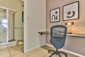 a office with a blue chair and a desk at The Piazza 1 Bedroom spacious apartment with Study in Cape Town +17 photos