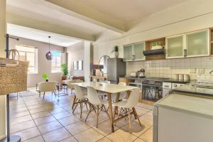 a kitchen and dining room with a table and chairs at The Piazza 1 Bedroom spacious apartment with Study in Cape Town