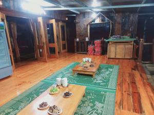 a living room with wooden floors and a table at Thai Culture Homestay in Mù Cang Chải