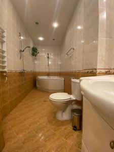 a bathroom with a toilet and a sink and a tub at hotel TEDI in Asenovgrad