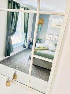 - un miroir dans une chambre avec un lit dans l'établissement MayDisc Long Stay Contractors Portsmouth Stays, à Portsmouth
