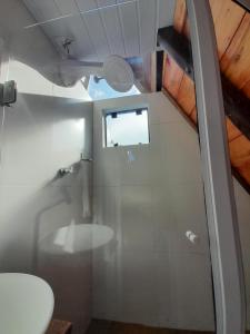 uma casa de banho com um chuveiro, um WC e uma janela. em Chalé A-Frame da Fazenda em Bom Jardim da Serra