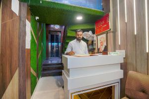 a man standing at a counter in a restaurant at Hotel Crown, Amritsar in Amritsar
