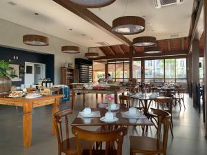 a restaurant with tables and chairs in a room at Quinta Santa Bárbara Pirenópolis in Pirenópolis