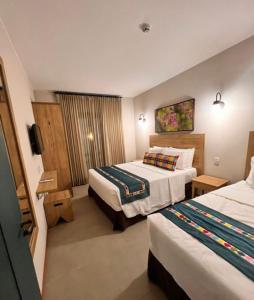 a hotel room with two beds and a television at Quinta Santa Bárbara Pirenópolis in Pirenópolis +72 photos
