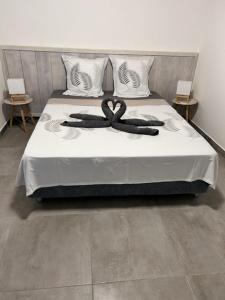 een slaapkamer met een bed met een grote witte sprei bij Arbre à pain in Bras-Panon