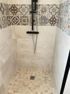 uma casa de banho com chuveiro e azulejos na parede em Location du Klan des K : villa 4 étoiles 150m plage em Les Sables Vignier