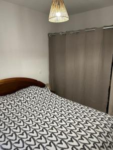 um quarto com uma cama com um edredão preto e branco em Location du Klan des K : villa 4 étoiles 150m plage em Les Sables Vignier