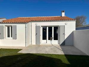 een wit huis met schuifdeuren en een tuin bij Location du Klan des K : villa 4 étoiles 150m plage in Les Sables Vignier