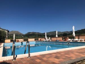 een groot zwembad met stoelen en parasols bij Rea Villa in Coltodino