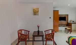 a living room with a table and two chairs at Treebo Premium Palmyra Milford, 2 Km From Alleppey Beach in Alleppey