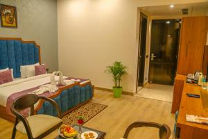 a bedroom with a bed and a table and chairs at Four Leaf Hotel, Kasganj in Kāsganj