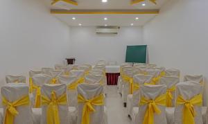 a room with rows of chairs with yellow bows at Treebo Tryst Palmyra Milford 2 Km From Alleppey Beach in Alleppey