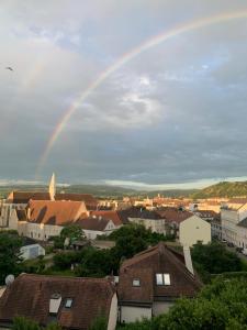 a rainbow in the sky over a town with houses at kremsoase in Krems an der Donau