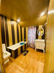 a bathroom with a tub and a toilet and a sink at House Boat New Pala Palace in Srinagar