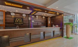 a lobby with a bar with clocks on the wall at Treebo Tryst Palmyra Milford 2 Km From Alleppey Beach in Alleppey