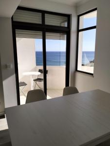 アルマカオ・デ・ペラにある8-2 Torre Sol - Casas & Papéisの海の景色を望む客室で、テーブルと椅子が備わります。