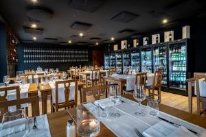un ristorante con tavoli, sedie e bottiglie di vino di Osteria Ascona ad Ascona