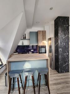 a kitchen with two stools at a counter in a kitchen at LUX Apartman Simi in Divčibare
