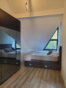 a bedroom with two beds and a large window at LUX Apartman Simi in Divčibare