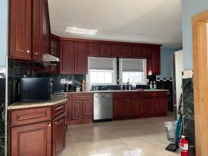 a kitchen with wooden cabinets and a white refrigerator at Airport room 33 in Boston