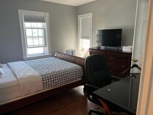 a bedroom with a bed and a desk and a television at Airport room 33 in Boston