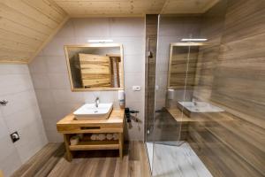 a bathroom with a sink and a shower at Apartmaji na kozolcu - Smogavc in Zreče