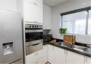 a kitchen with a stainless steel refrigerator and a sink at Luxury apartment in Gordons Bay in Gordonʼs Bay