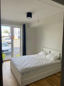 a white bed in a room with a window at Uhiuus Mai tänava korter in Pärnu