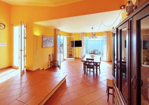 ein Wohnzimmer mit gelben Wänden sowie einem Tisch und Stühlen in der Unterkunft Solemar Sicilia - Villa Elis in Bagheria