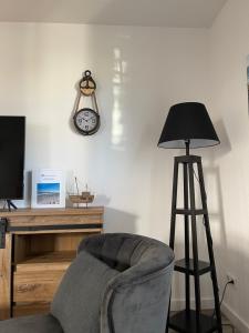 a room with a chair and a clock on the wall at MeinStrandNest in Juliusruh