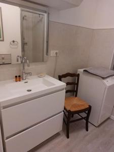 Elle comprend une petite salle de bains pourvue d'un lavabo et d'une chaise. dans l'établissement Appartement avec balcon à côté de la plage, à Tourgéville