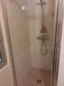 La salle de bains est pourvue d'une douche avec une porte en verre. dans l'établissement Appartement avec balcon à côté de la plage, à Tourgéville