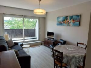 - un salon avec un canapé et une table dans l'établissement Appartement avec balcon à côté de la plage, à Tourgéville