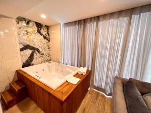 a bathroom with a bath tub and a couch at Old Town Point Hotel & Spa Antalya in Antalya
