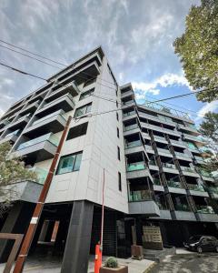 a tall white building with a car parked in front of it at Blue Bike Residence Mamaia Studio in Mamaia