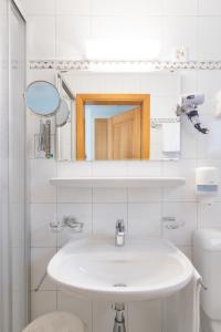 een witte badkamer met een wastafel en een spiegel bij Osteria Ascona in Ascona